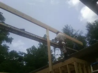Carpenter setting a ridge beam over a new addition frame — Ice Dam Removal by Roofing Brothers in Fort Cobb