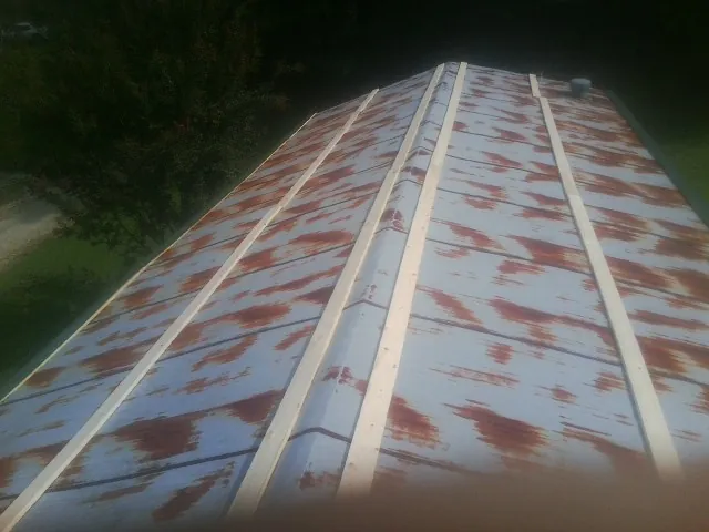 Rusted metal roof panels with new wood purlins before replacement — Storm Damage Roof Repair in Fort Cobb by Roofing Brothers