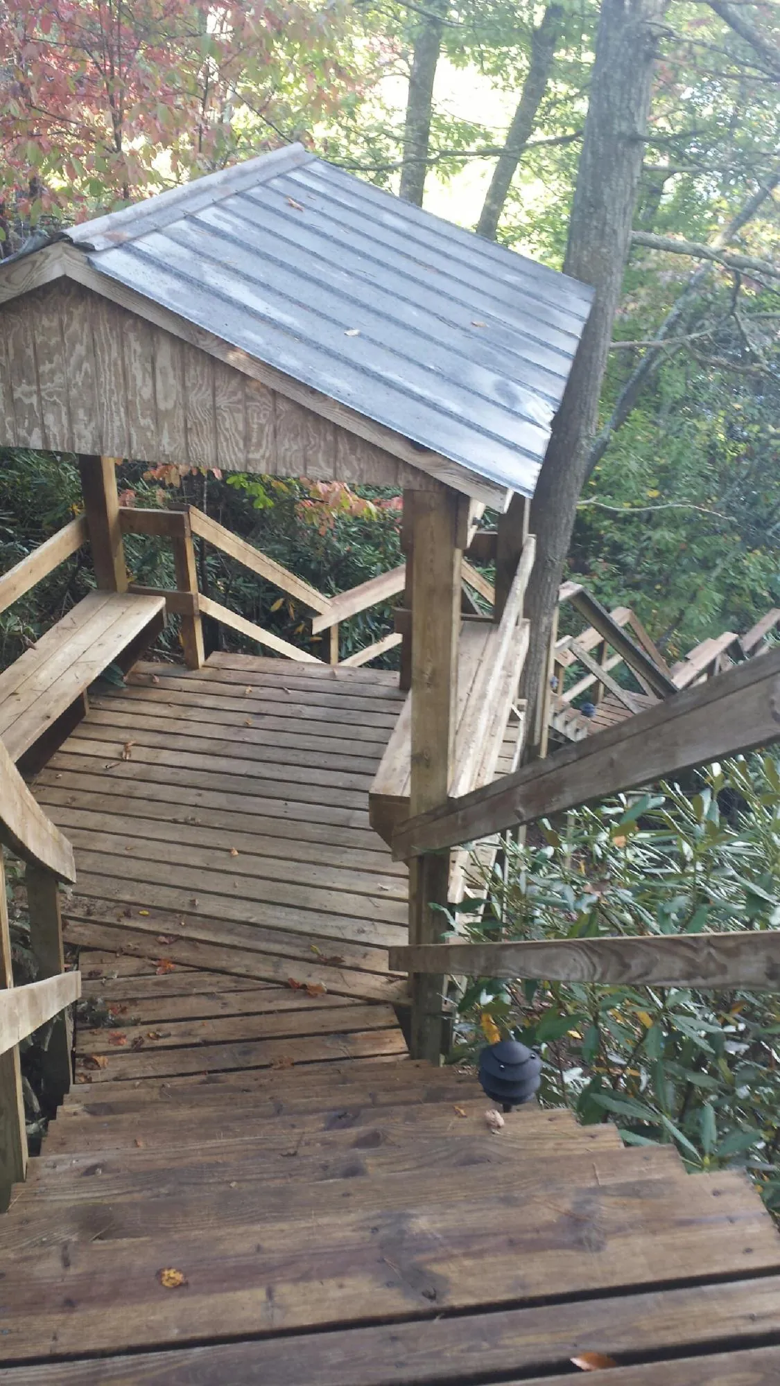 Metal roofed shelter over wooden steps on a wooded walkway — Skylight Repair & Installation work by our crew in Fort Cobb