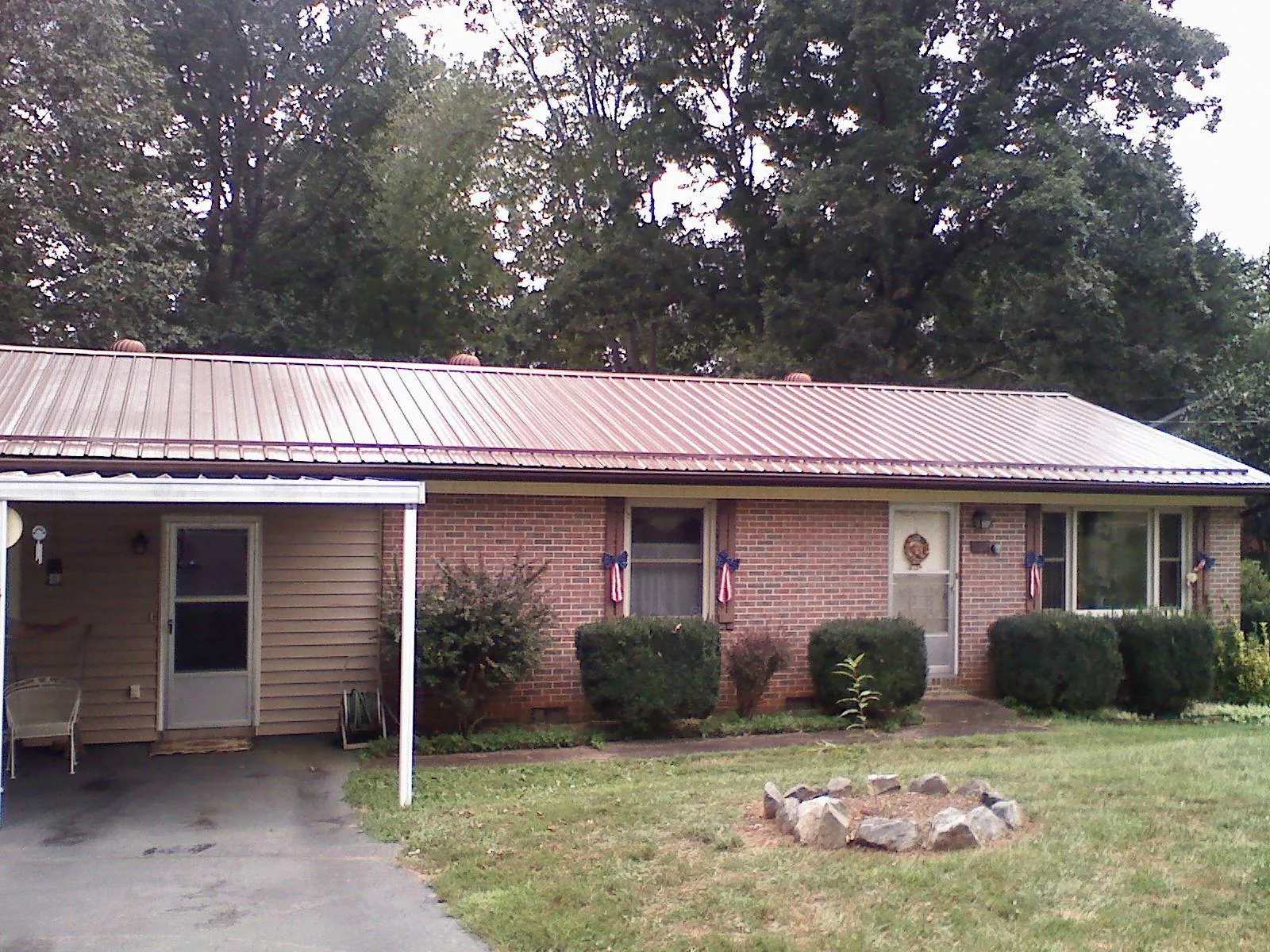 Bronze metal roof and carport on a brick ranch home — Roof Repair work by our crew in Fort Cobb